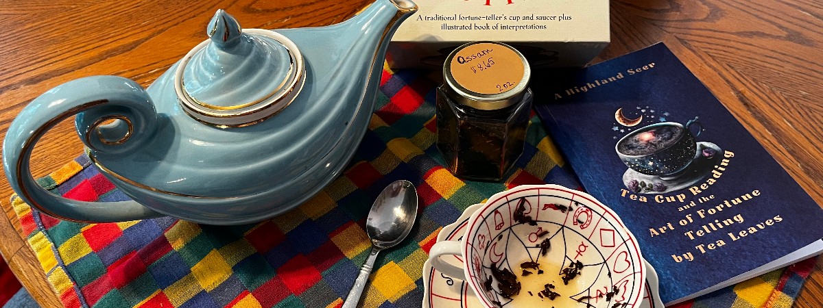 A tea pot, tea cup with tea leaves