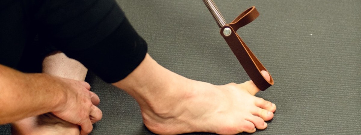 A woman using a Rescue Loop for toe exercises
