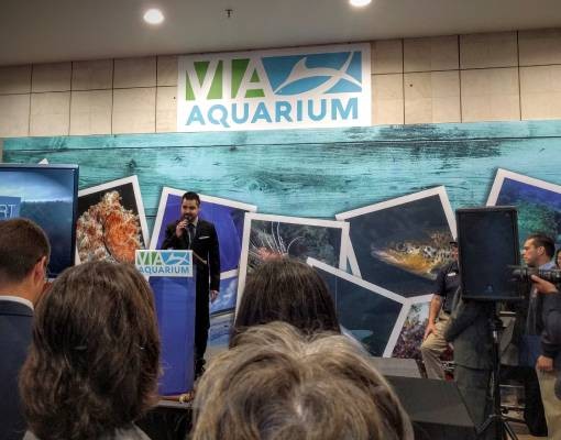 man at podium at aquarium
