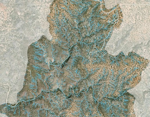 An overhead view of a desert area with small dots and blue lines.