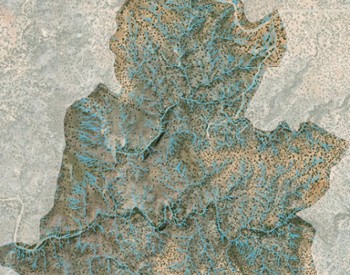 An overhead view of a desert area with small dots and blue lines.