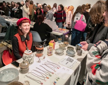 A woman sells jewelry at a table