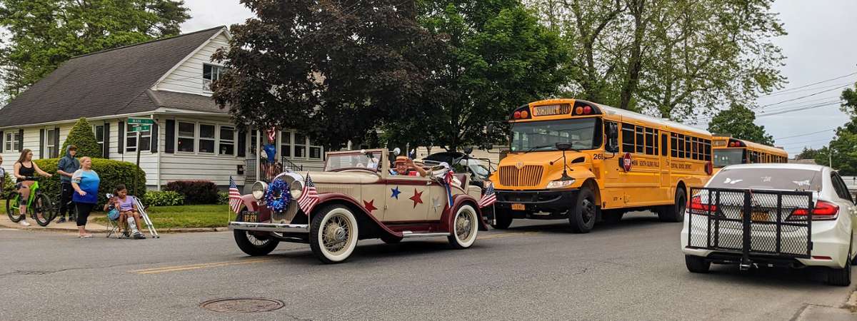 old fashioned car and school bus in parade