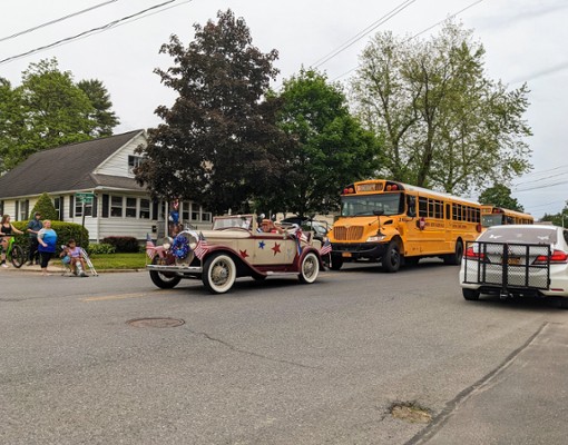 old fashioned car and school bus in parade