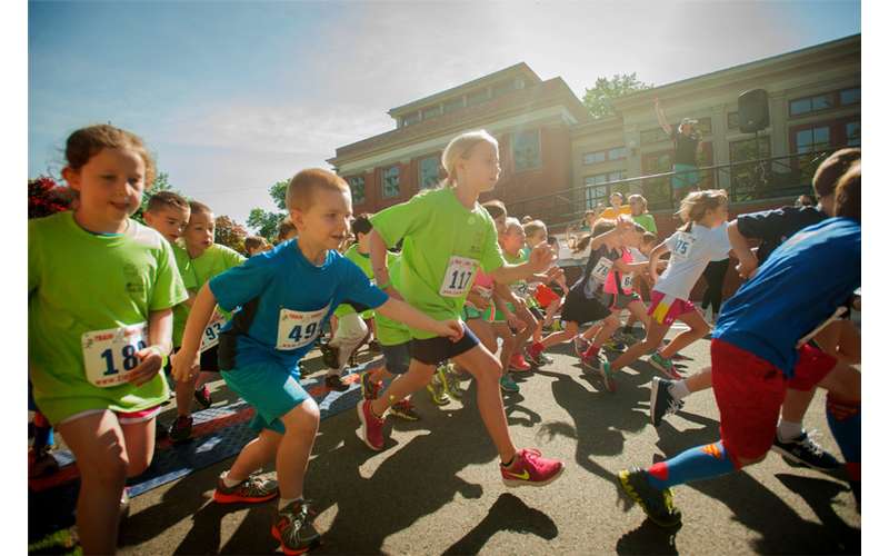 large group of kids in a race down the street