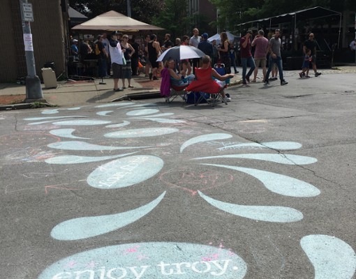 painted rain drops on cement, one says enjoy troy