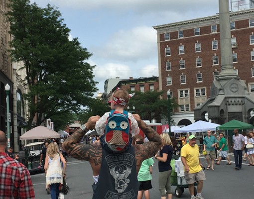 crowd, little girl with owl backpack on her dad's shoulders