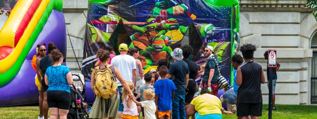 MVP Kids Day crowd at a ninja turtles bounce house