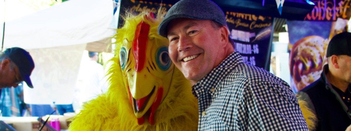 man next to person dressed as a chicken