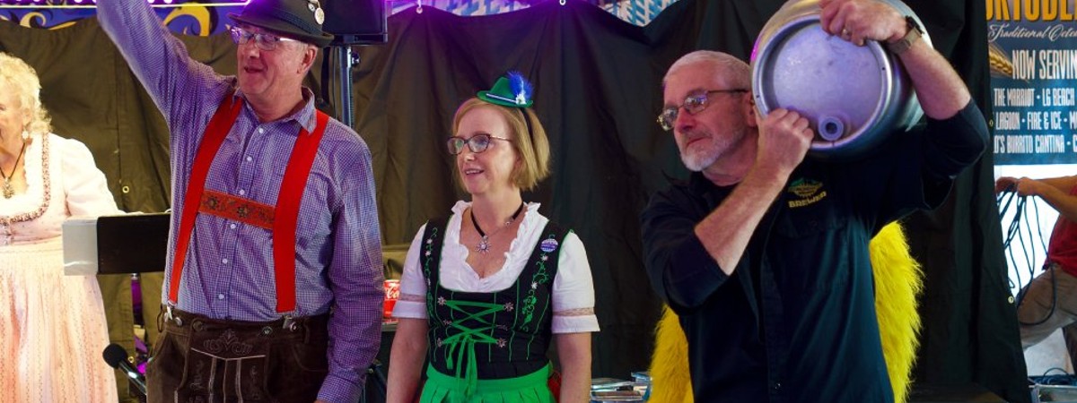 three people on stage at Oktoberfest event