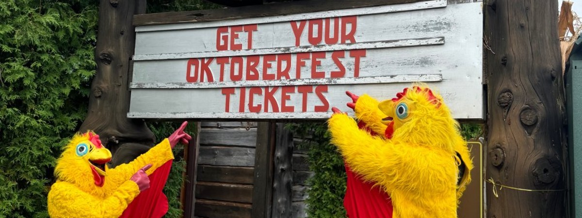 two people dressed as chickens in front of ADK Brewery sign