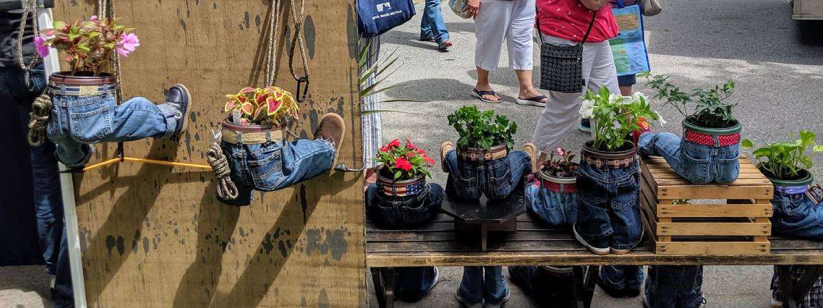 plant vendor at festival with plants in jeans