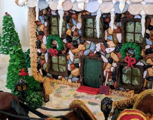 gingerbread house with sign that says adirondack christmas