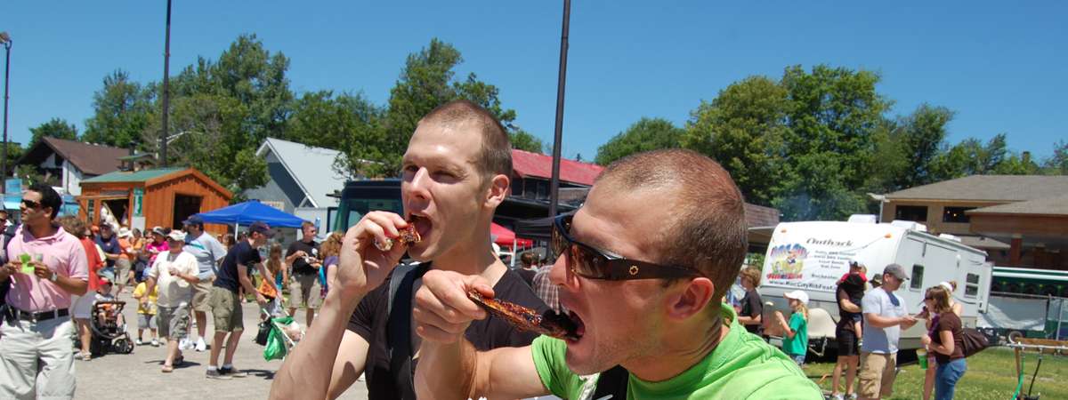 two guys eating barbecue food