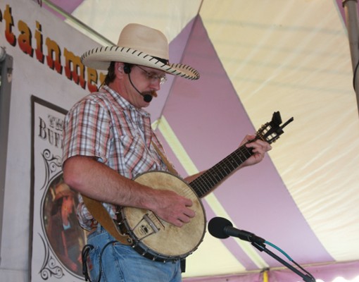 man with plaid shirt and cowboy hat performing