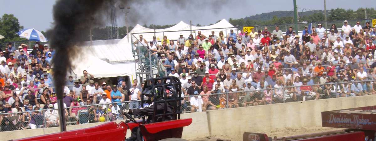 a tractor pull, crowd in the background