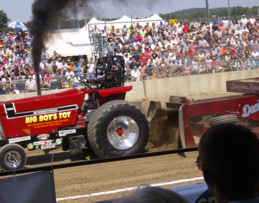 a tractor pull, crowd in the background