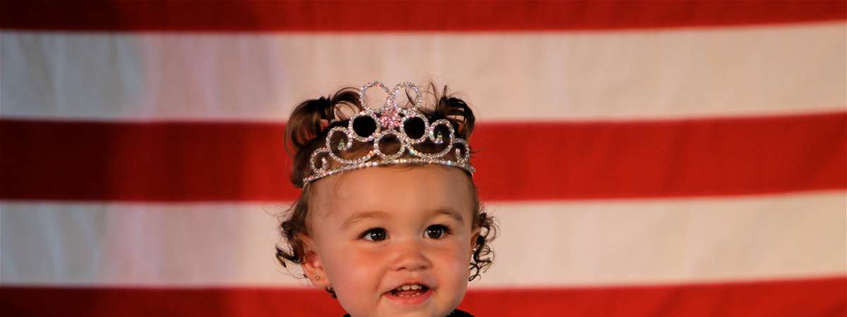 toddler with crown and sash