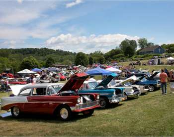 a row of classic cars on large field