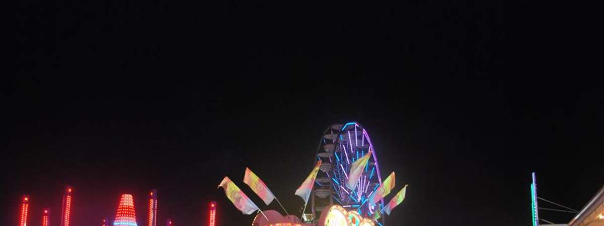 a view of food vendors during the night at a fair