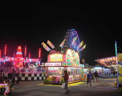 a view of food vendors during the night at a fair