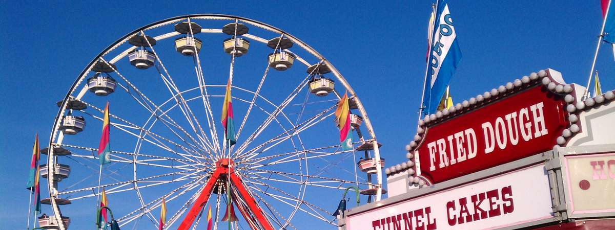 ferris wheel with food stand next to it