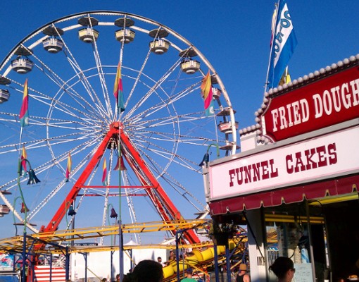 ferris wheel with food stand next to it