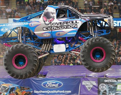 a large blue monster truck in the air