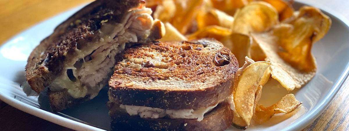 turkey sandwich on rye with potato chips