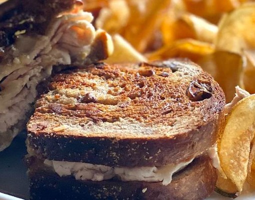 turkey sandwich on rye with potato chips