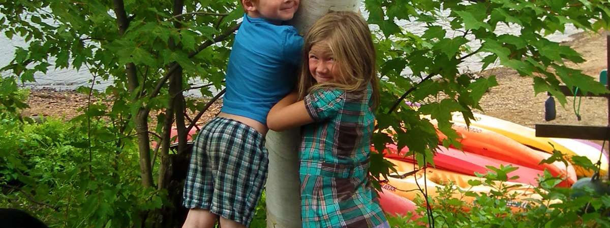 two kids hugging a tree