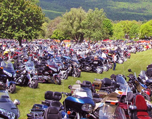 a large group of motorcycles on a grassy field