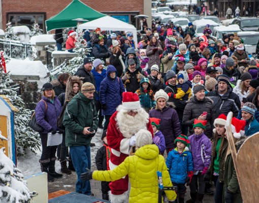crowd of people on sidewalk near Santa
