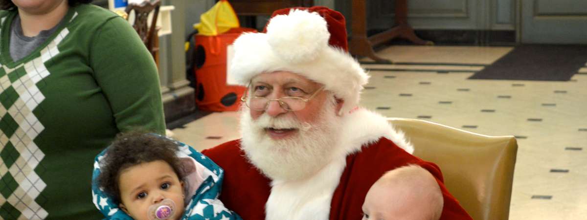 santa holding two young babies