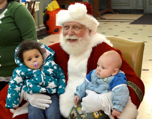 santa holding two young babies