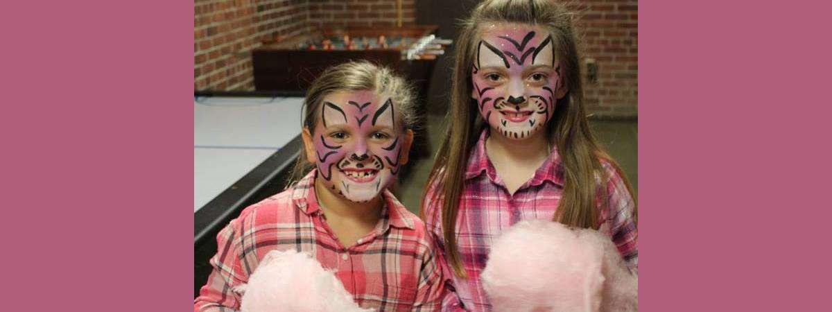 girls at ticonderoga end of winter carnival with faces painted like tigers