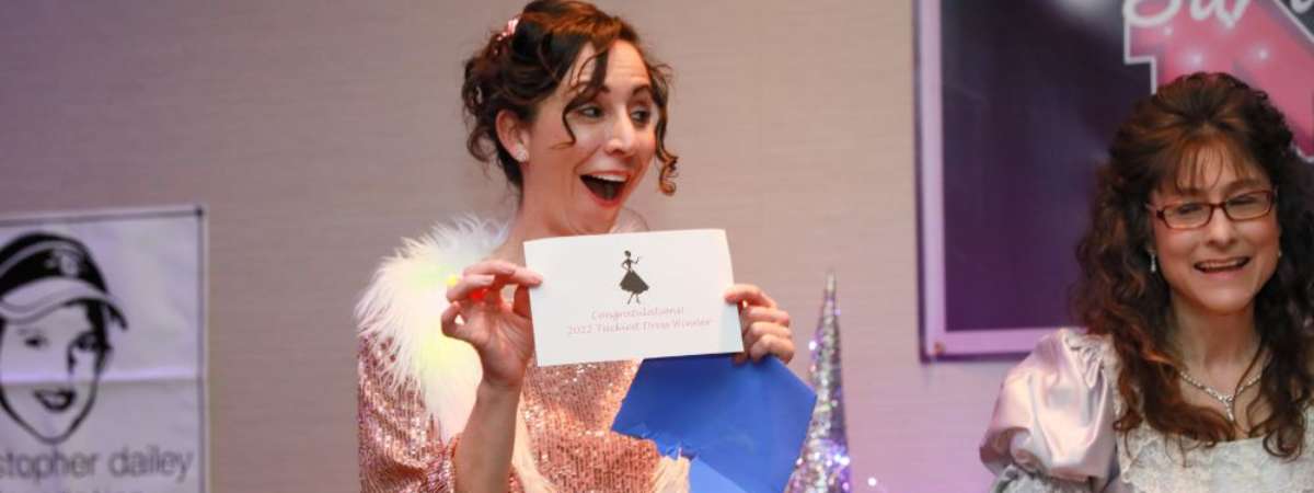 woman holding up a card at a mom prom