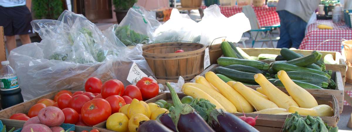 eggplant, squash, and more vegetables at a market stand