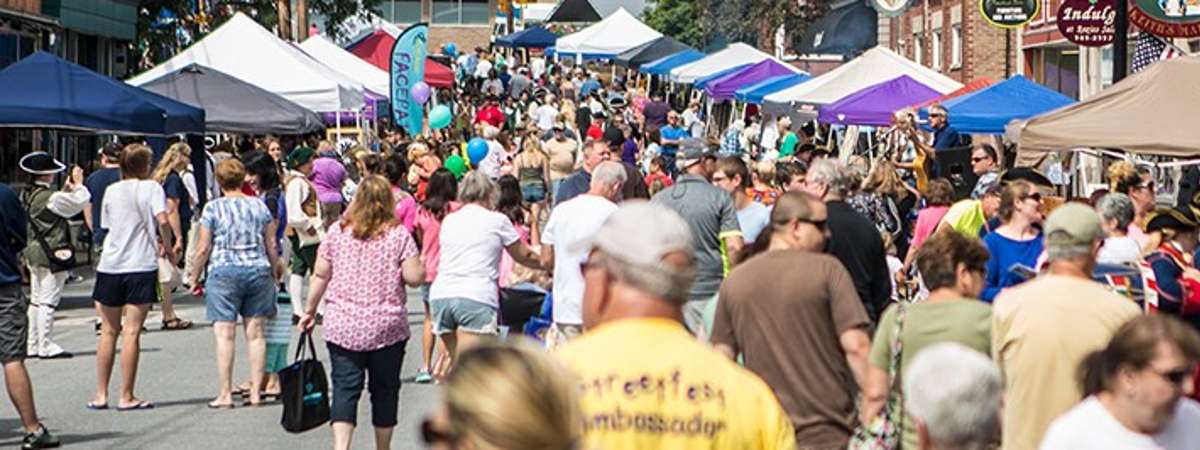crowds browsing vendor tents on montcalm street in ticonderoga
