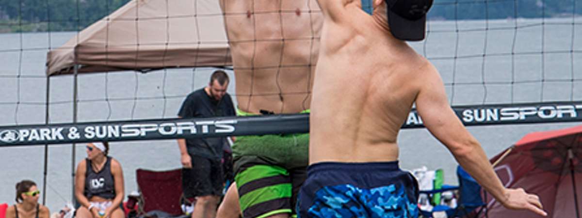 player hitting volleyball over net