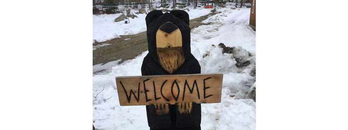 wooden bear holding Welcome Got Maple sign