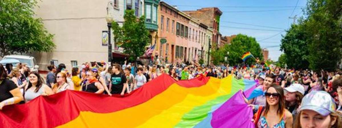 people holding pride flag in a parade