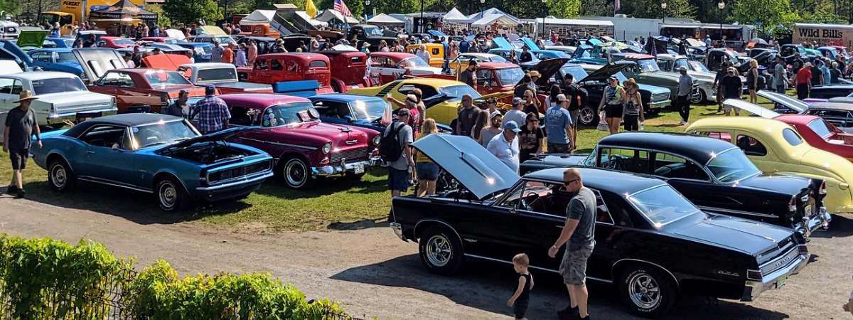 crowds and cars at car show in park