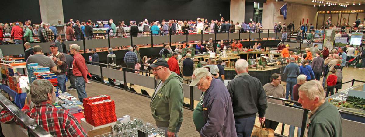 people walking around a model train expo