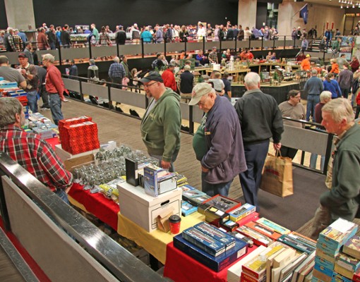 people walking around a model train expo