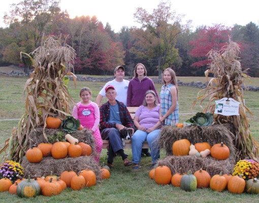 people posing near pumpkins