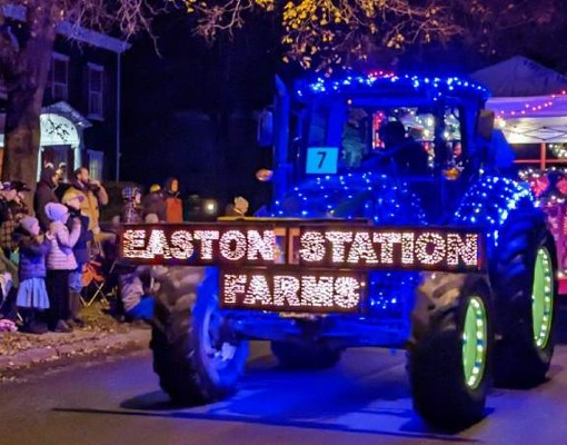 tractor in tractor parade with lights that spell out easton station farms