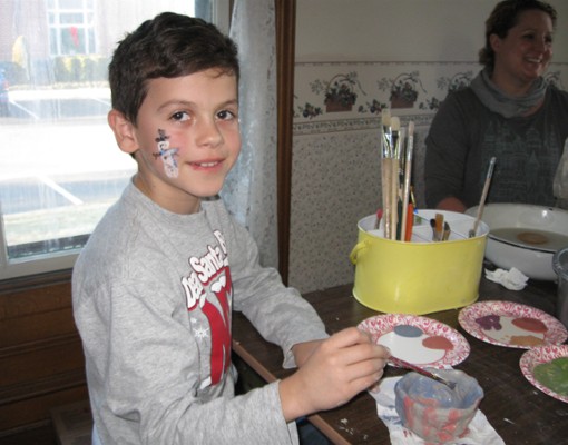 boy with holiday face paint and crafts