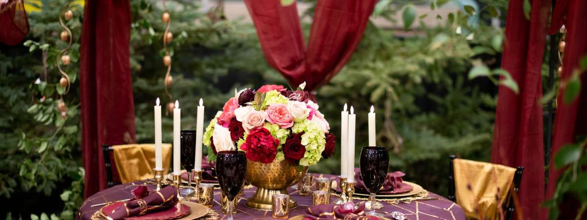 table set with candles, glasses, and flowers