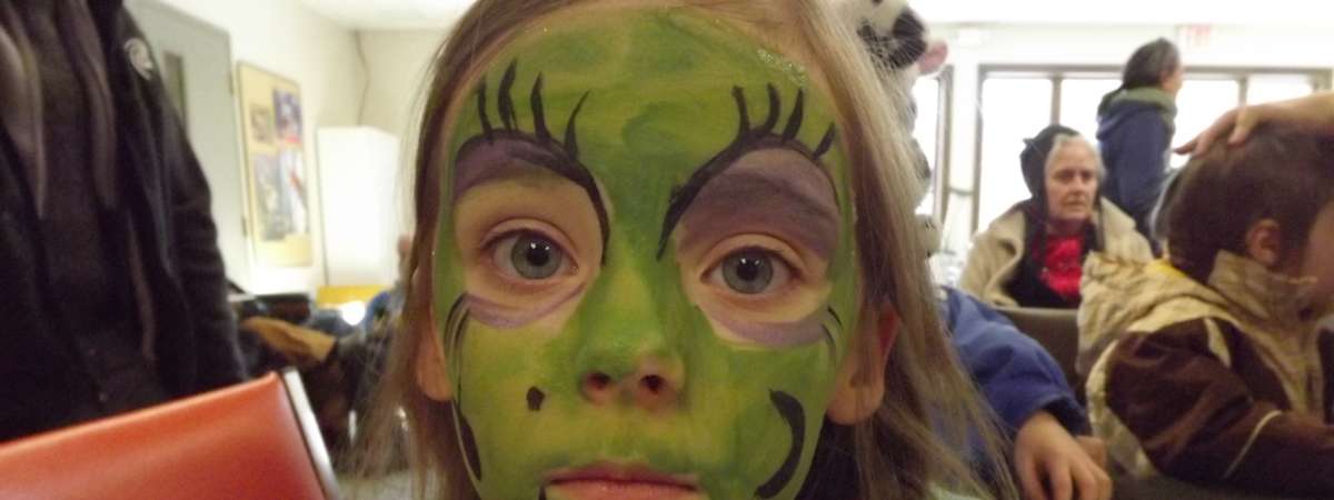 a girl with green face paint on